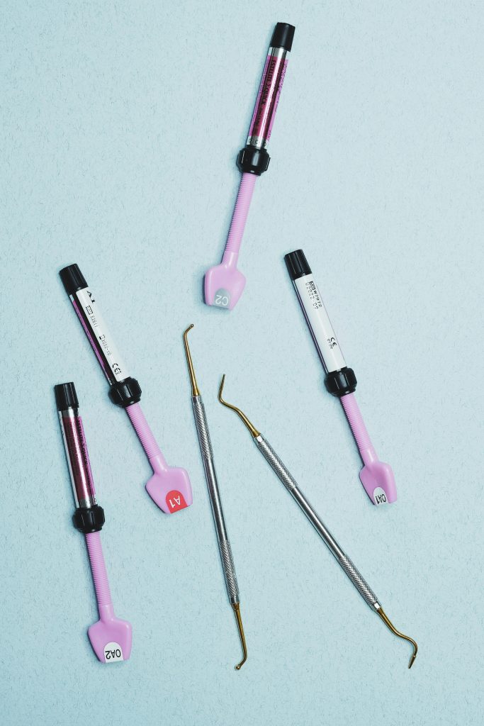 Close-up of dental instruments and tools on a light blue surface.
